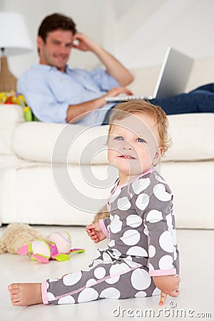 Father working at home while looking after child