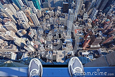 Feet on the edge of tall building