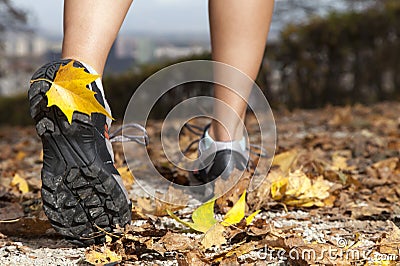 Feet of a runner in autumn leaves