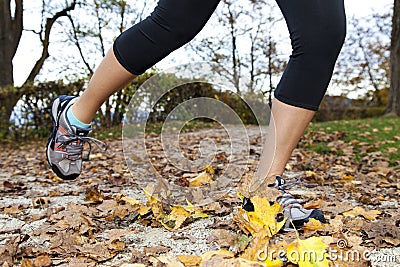 Feet of a runner in autumn leaves