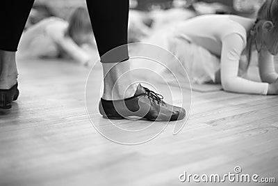 Feet of trainer in ballet school for small girs