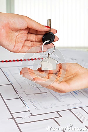 Female architect hand,handing over house key to a customer.