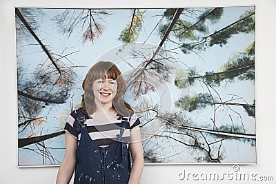 Female Artist Standing In Front Of Large Painting