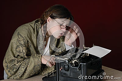 Female author typing on an old typewriter