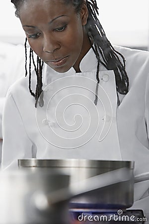 Female Chef Cooking In Kitchen