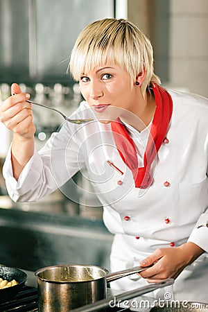 Female Chef in a restaurant kitchen tasting