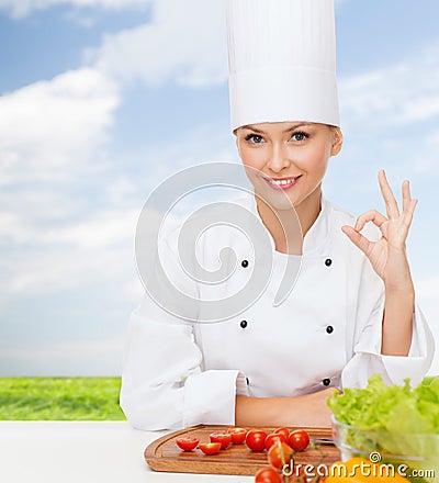 Female chef with vegetables showing ok sign