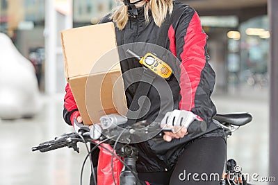 Female Cyclist With Cardboard Box And Courier Bag
