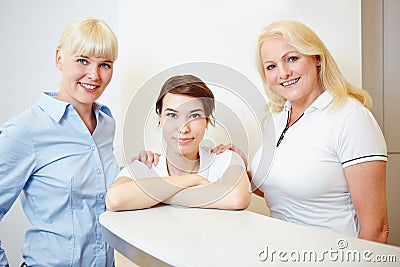 Female dentist with doctors assistant and receptionist