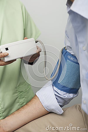 Female Doctor Checking Blood Pressure Of Patient