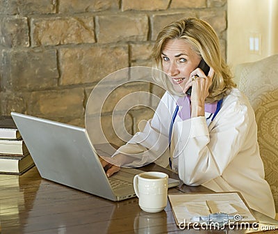 Female Doctor at her desk and on the telephone