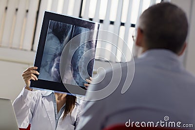 Female doctor in hospital with patient and x-rays