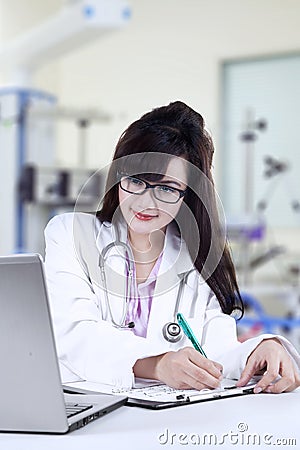 Female doctor making prescription