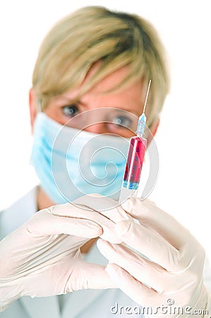 Female doctor with mask holding a syringe