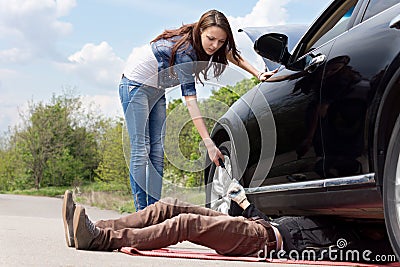 Female driver assisting a mechanic on her car