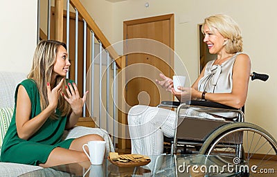 Female friend visiting disabled woman