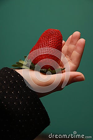 Female hand holding giant strawberry