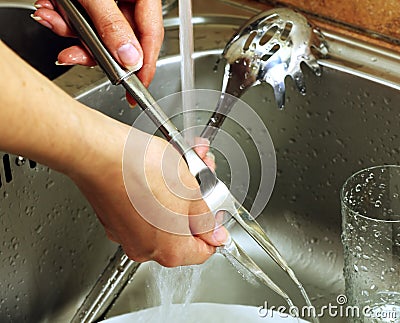 Female hands wash different kitchen utensils