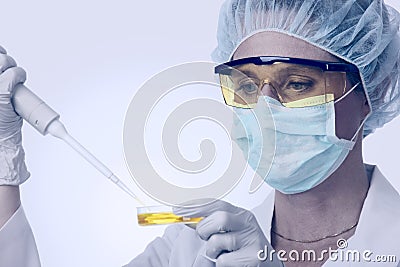 Female lab technician with pipette and liquid