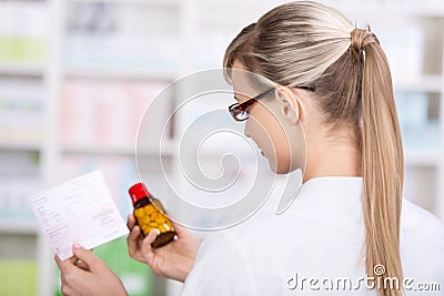 Female pharmacist holds prescription and medicine