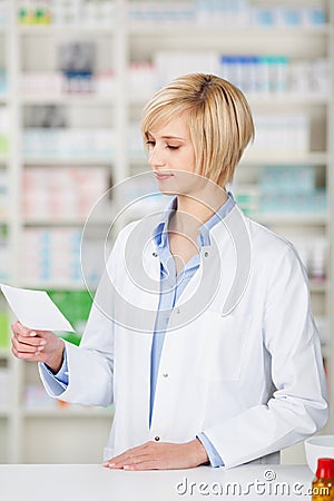 Female pharmacist looking at prescription