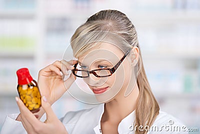 Female pharmacist reading the medicine label