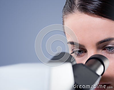 Female researcher using microscope close up