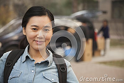 Female smiling student portrait in front of dormitory at college