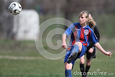 Female soccer player kicking the ball