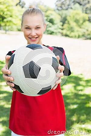 Female soccer player showing ball at park