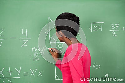 Female Teacher Solving Mathematics On Board