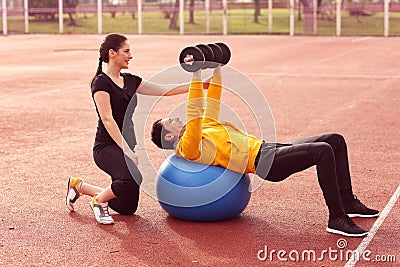 Female trainer with man exercising