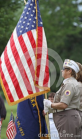 Female Veteran in uniform with American Flag