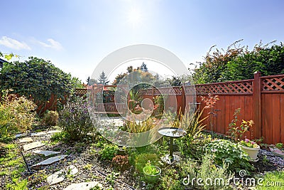 Fenced backyard with garden and hanging bench