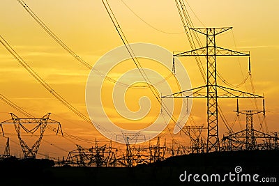 Field of high voltage towers under dramatic sky