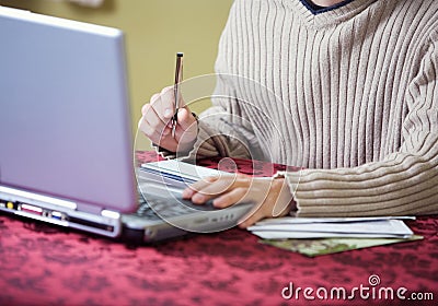 Finances: Man At Laptop Writing Checks For Bills