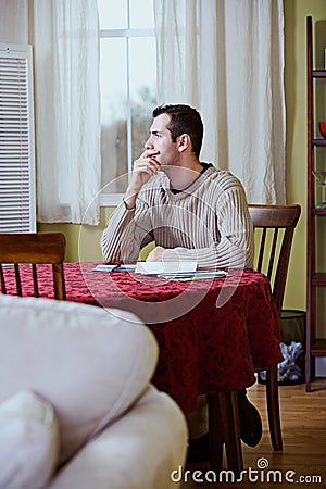 Finances: Man Pauses To Think While Paying Bills