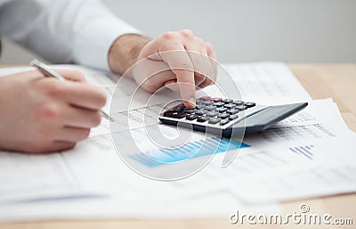 Financial data analyzing. Counting on calculator.