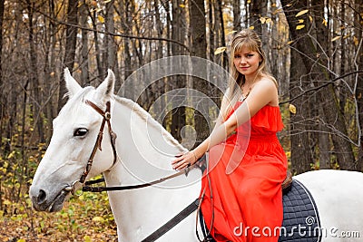 Fine young woman on horseback on white horse
