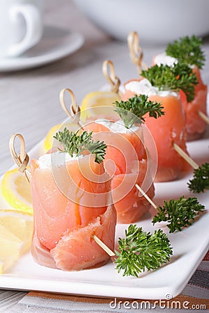 Finger food. Rolls of salmon closeup on the table vertical