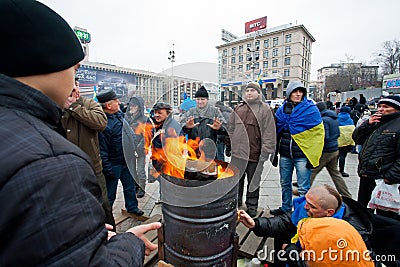 Fire on the cold main Maidan square with people oc