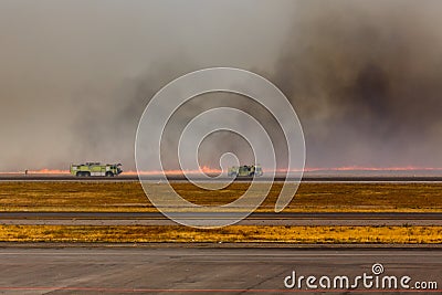 Fire trucks approach Airport Brush Fire in El Salvadore