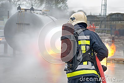 Firefighter extinguishing tank fire