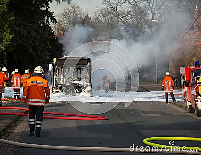 Firefighters extinguish a burning bus
