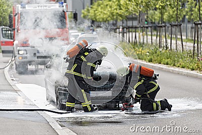 Firefighters are putting out a burning car