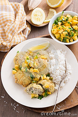 Fish cakes with mango salsa and white rice, top view, vertical