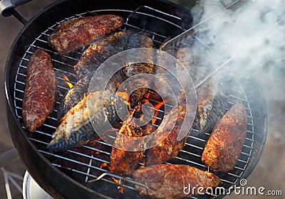 Fish fillets on the grill with flames