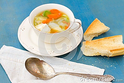 Fish soup with silver spoon