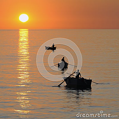 Fisherman on beautiful calm bay at sunrise