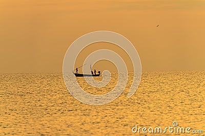 Fisherman on the boat over dramatic sunset